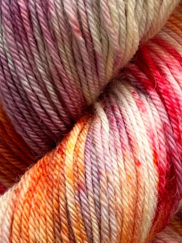 Håndfarvet garn i bluefaced leicester uld. Dette håndfarvede bfl garn er farvet med smukke nuancer af lilla, pink og orange