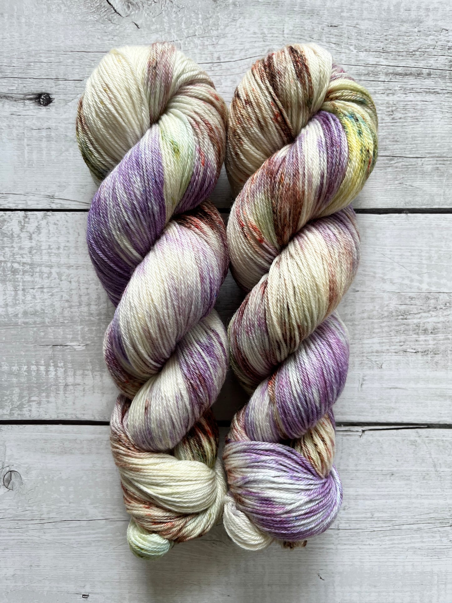 Håndfarvet garn i Merino Bamboo uld. Dette håndfarvede strømpegarn er farvet med smukke nuancer af lilla, grøn og brun