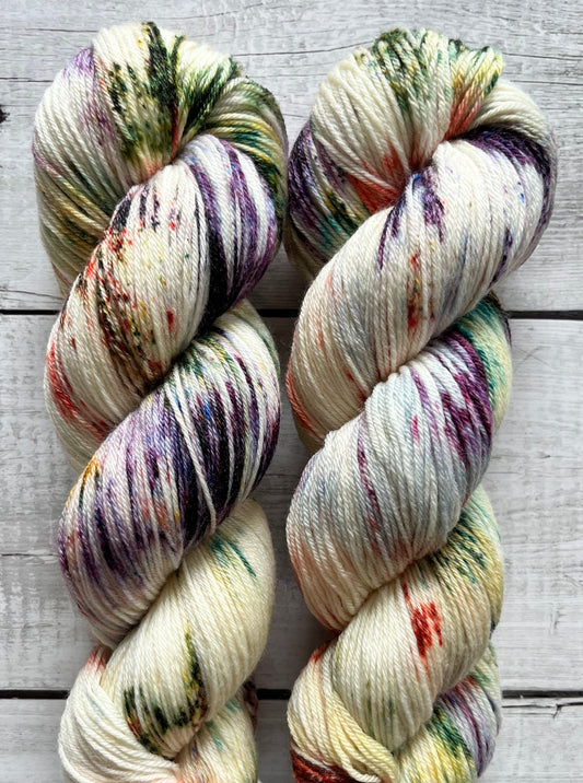 Håndfarvet garn i Merino Bamboo uld. Dette håndfarvede strømpegarn er farvet med smukke nuancer af lilla, grøn og rød