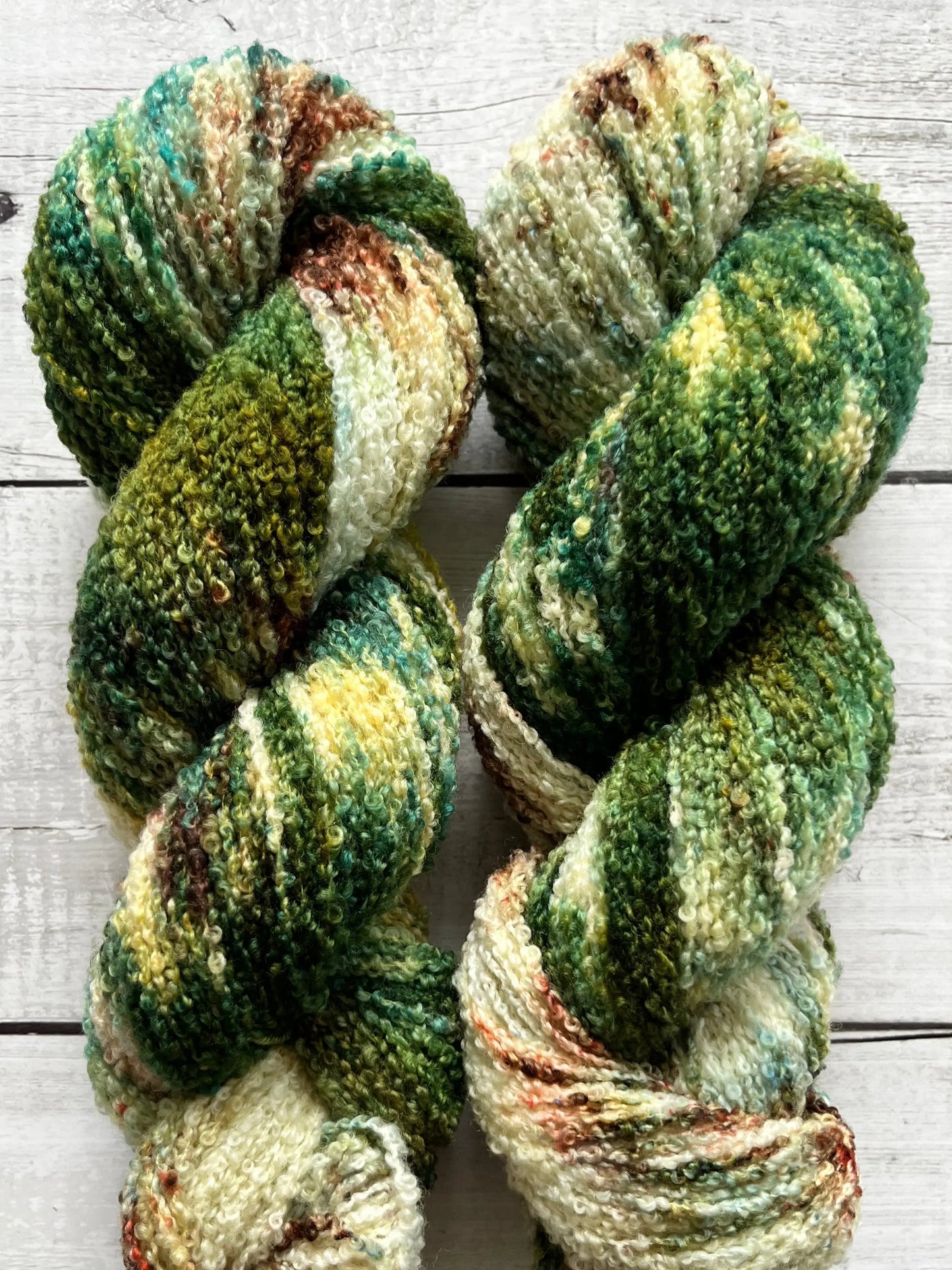 Håndfarvet garn i Merino Bouclé uld. Dette håndfarvede Merino Bouclé er farvet med smukke nuancer af mørkegrøn og brun