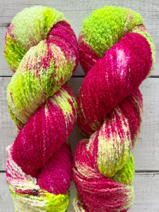 Håndfarvet garn i Merino Bouclé uld. Dette håndfarvede Merino Bouclé er farvet med smukke nuancer af pink og neon grøn