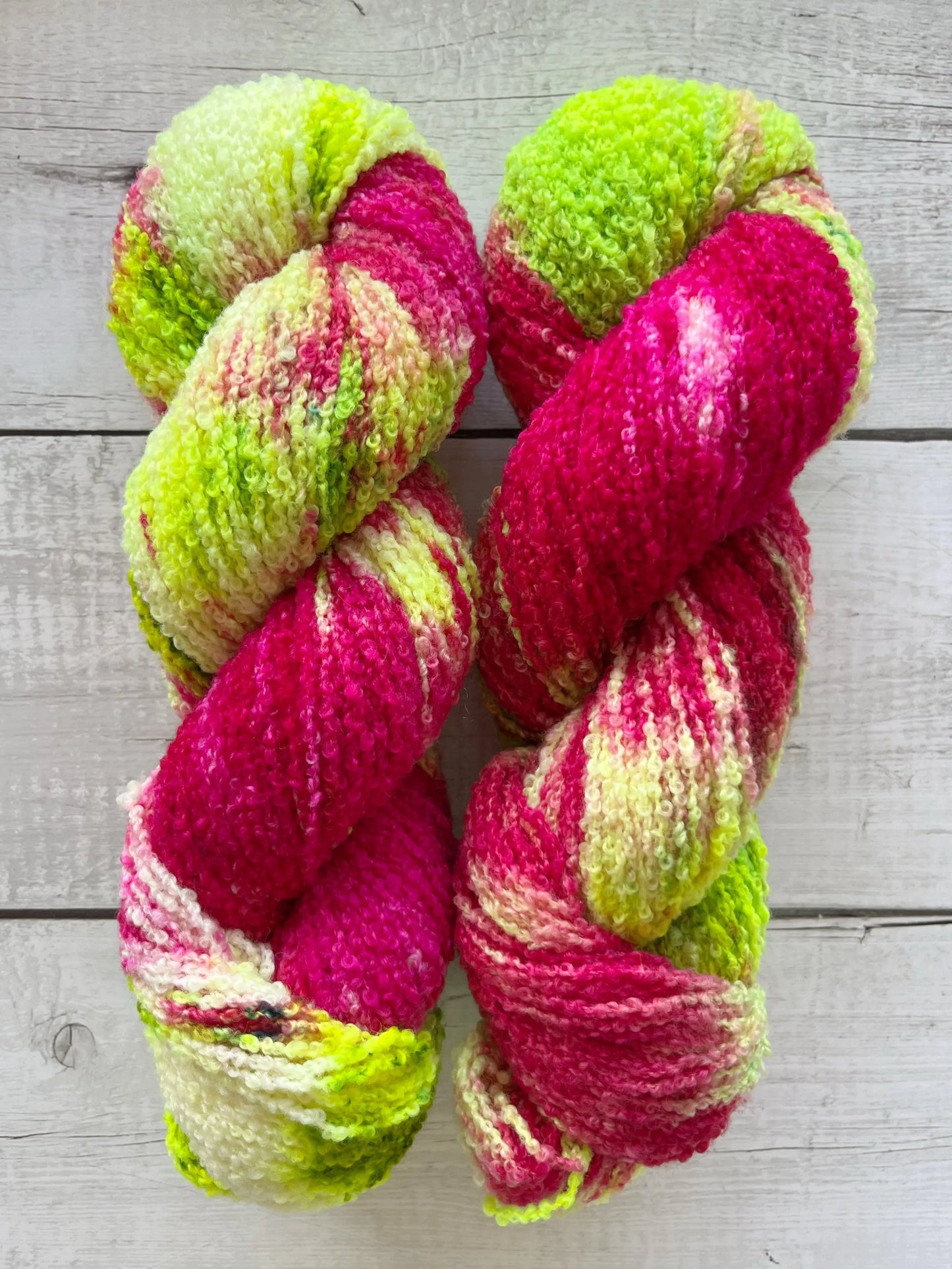Håndfarvet garn i Merino Bouclé uld. Dette håndfarvede Merino Bouclé er farvet med smukke nuancer af pink og neon grøn