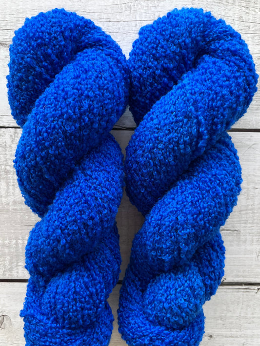 Håndfarvet garn i Merino Bouclé uld. Dette håndfarvede Merino Bouclé er farvet i en smuk blå nuance