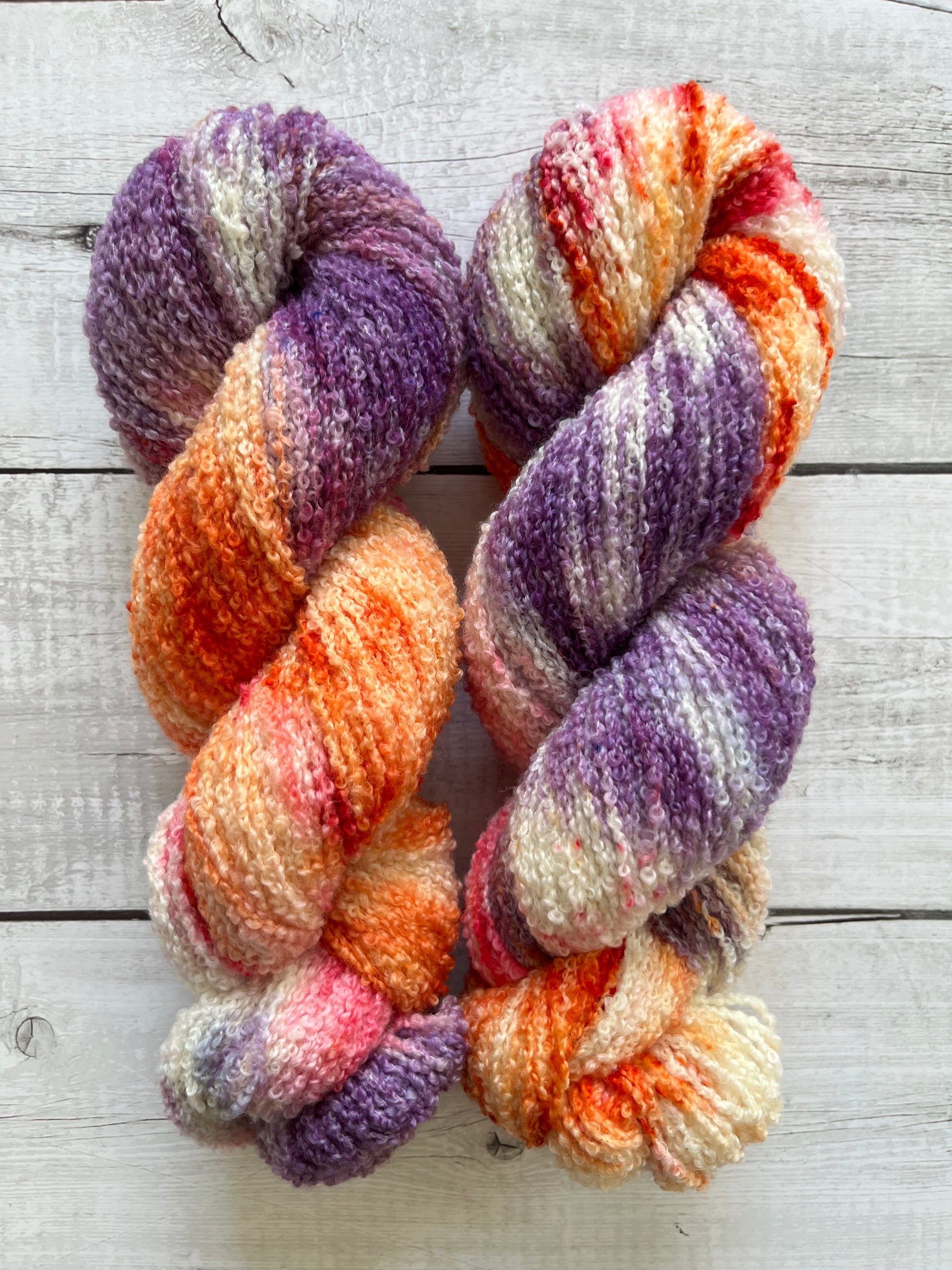 Håndfarvet garn i Merino Bouclé uld. Dette håndfarvede Merino Bouclé er farvet med smukke nuancer af lilla, pink og orange