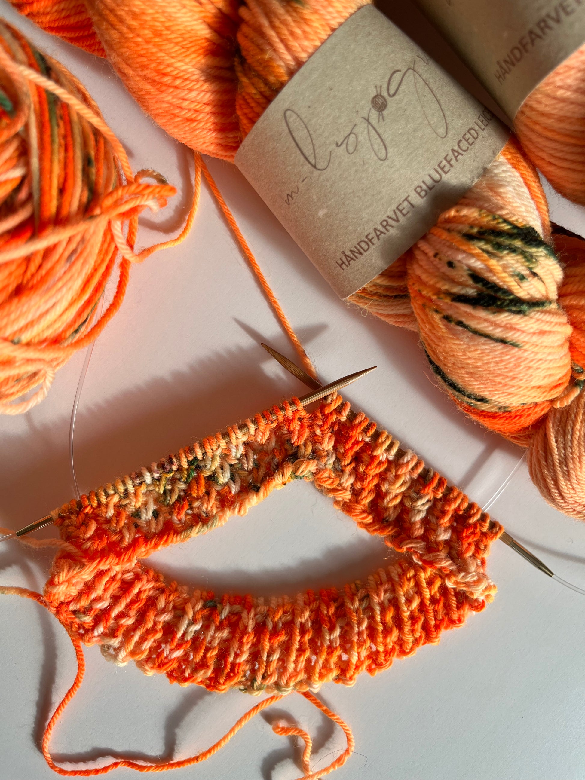 Håndfarvet garn i bluefaced leister uld. Dette håndfarvede bfl garn er farvet med smukke nuancer af orange, grøn og mørk lilla