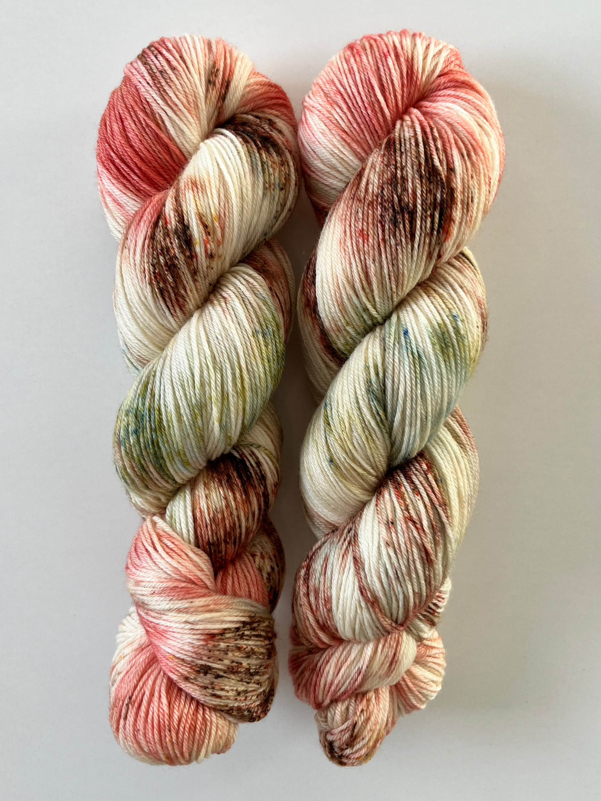Håndfarvet garn i Merino Bamboo uld. Dette håndfarvede strømpegarn er farvet med smukke nuancer af brun, grøn og coral rosa