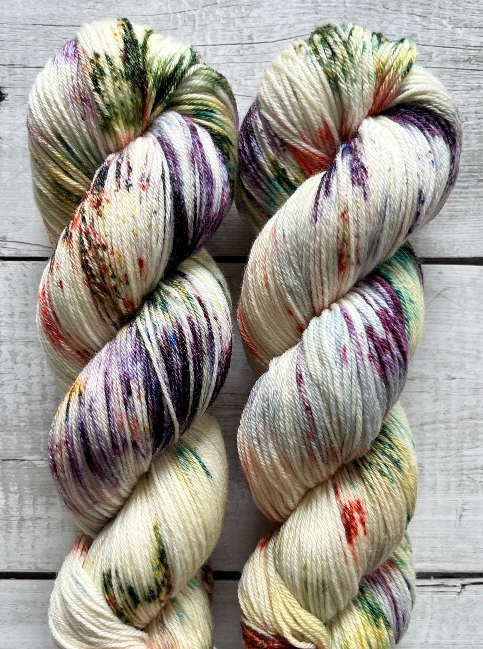 Håndfarvet garn i Merino Bamboo uld. Dette håndfarvede strømpegarn er farvet med smukke nuancer af lilla, grøn og rød