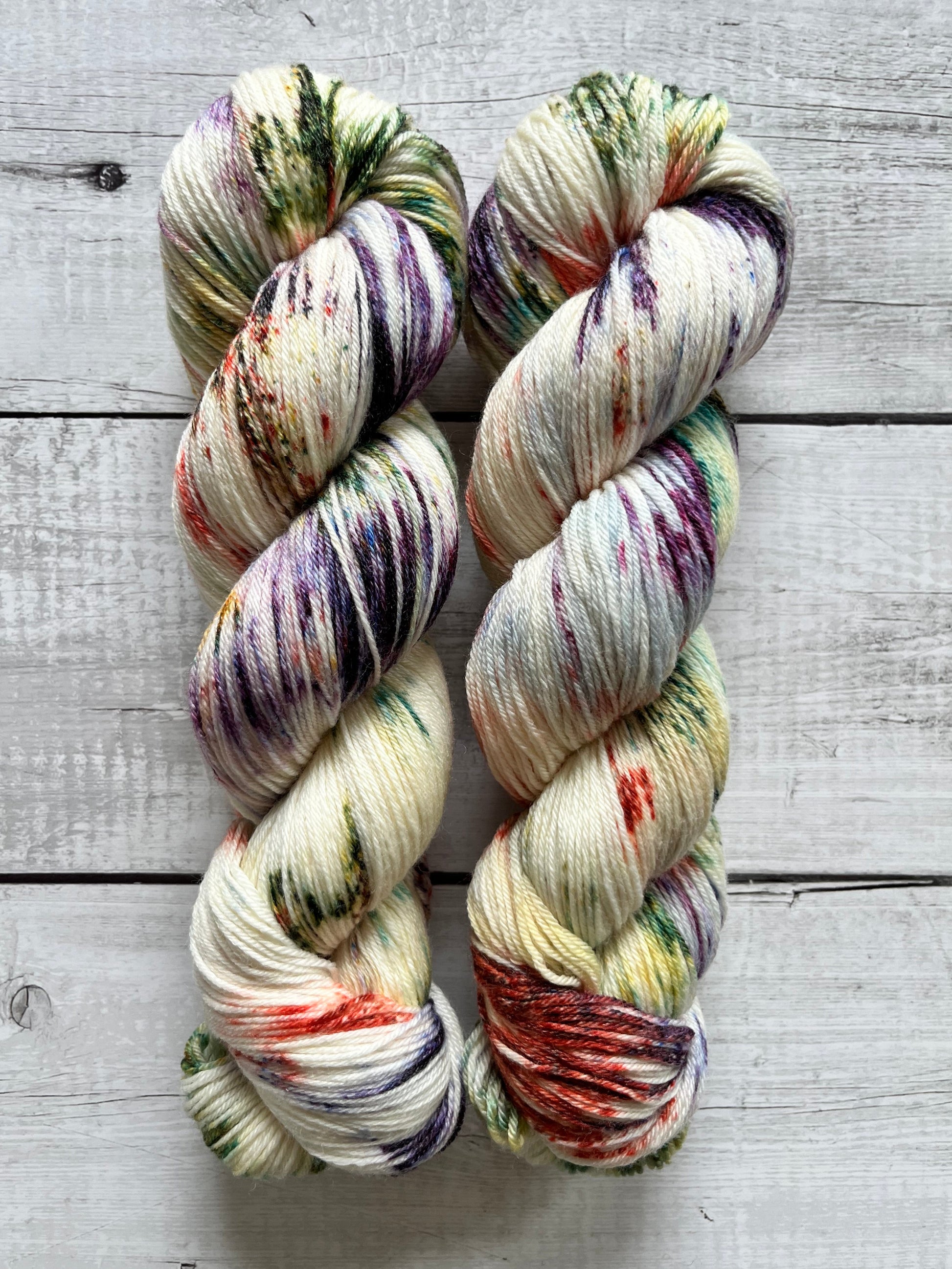 Håndfarvet garn i Merino Bamboo uld. Dette håndfarvede strømpegarn er farvet med smukke nuancer af lilla, grøn og rød