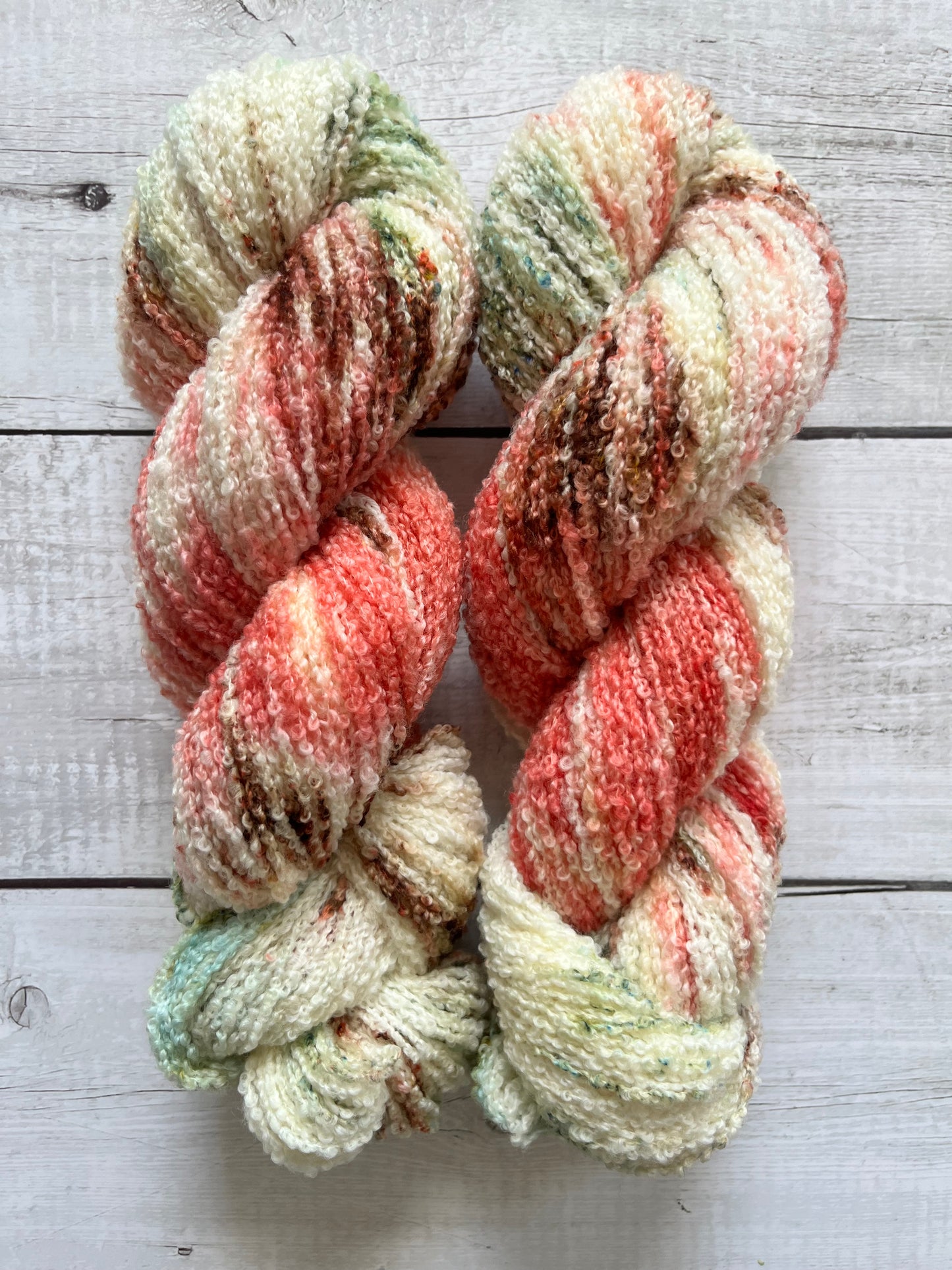 Håndfarvet garn i Merino Bouclé uld. Dette håndfarvede Merino Bouclé er farvet med smukke nuancer af coral rosa, grøn og brun