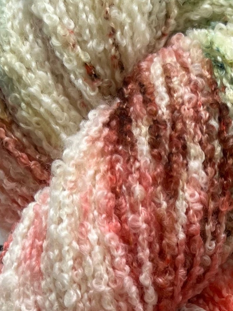 Håndfarvet garn i Merino Bouclé uld. Dette håndfarvede Merino Bouclé er farvet med smukke nuancer af coral rosa, grøn og brun