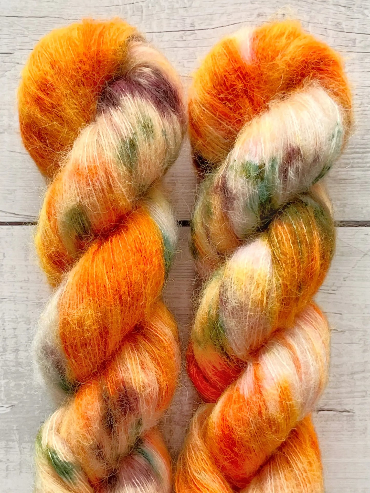 Håndfarvet Suri Alpaca Silk er den blødeste følgetråd, og et godt alternativ til mohair. Håndfarvet garn i alpakka og silke. Garnet er håndfarvet i smukke nuancer af orange, grøn og lilla