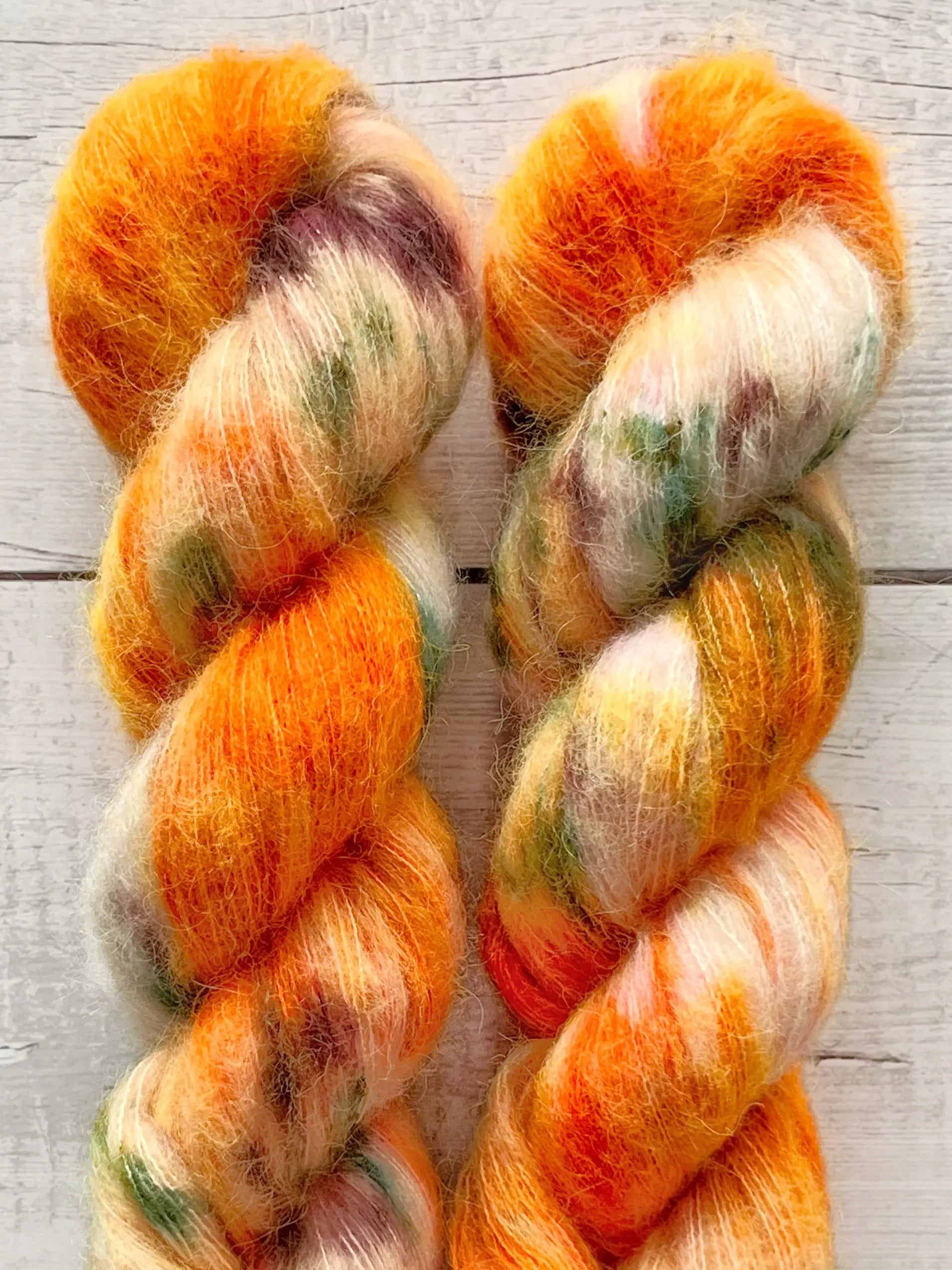 Håndfarvet Suri Alpaca Silk er den blødeste følgetråd, og et godt alternativ til mohair. Håndfarvet garn i alpakka og silke. Garnet er håndfarvet i smukke nuancer af orange, grøn og lilla