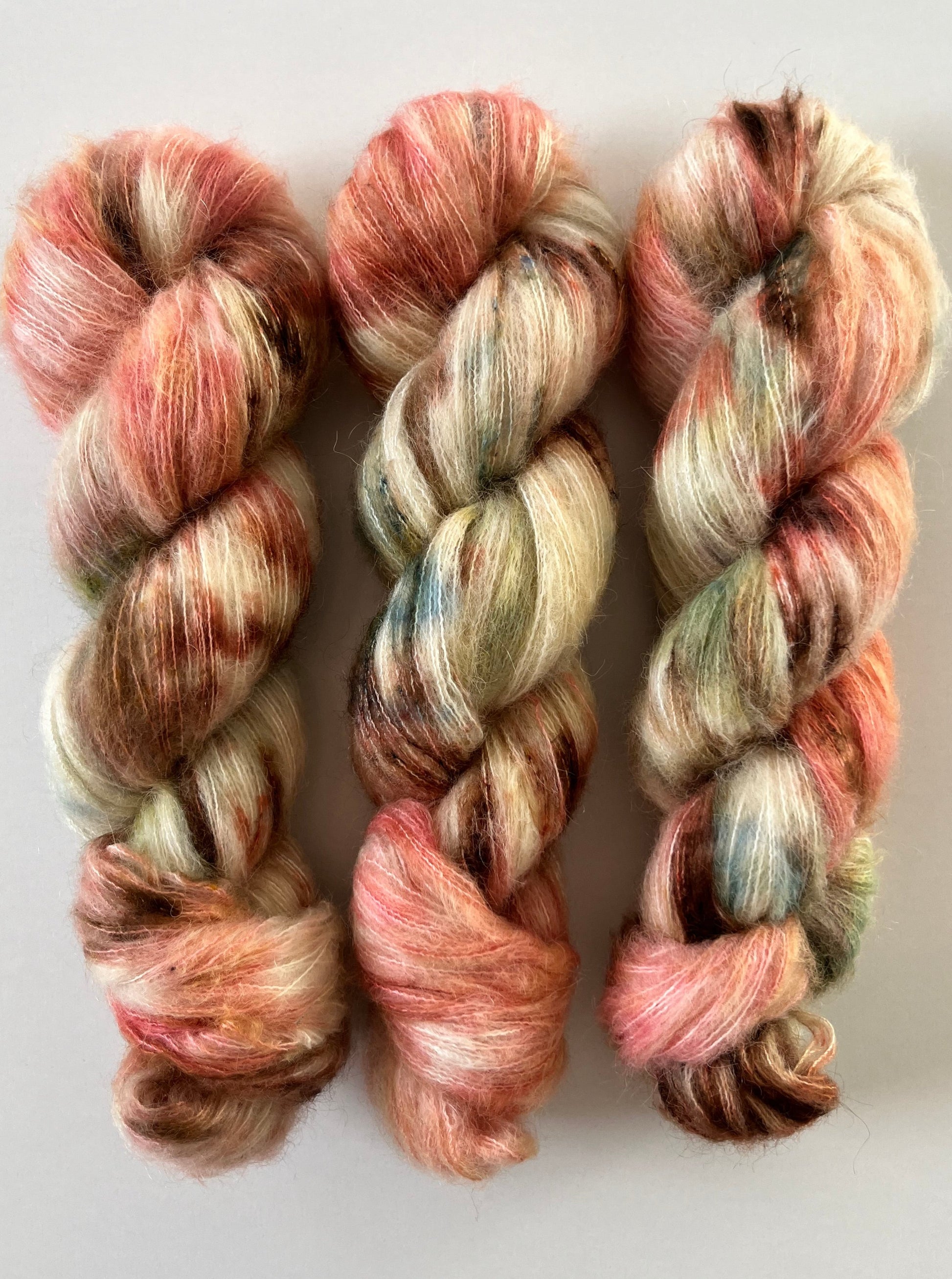 Håndfarvet Suri Alpaca Silk er den blødeste følgetråd, og et godt alternativ til mohair. Håndfarvet garn i alpakka og silke. Garnet er håndfarvet i smukke nuancer af coral rosa, grøn, blå og brun