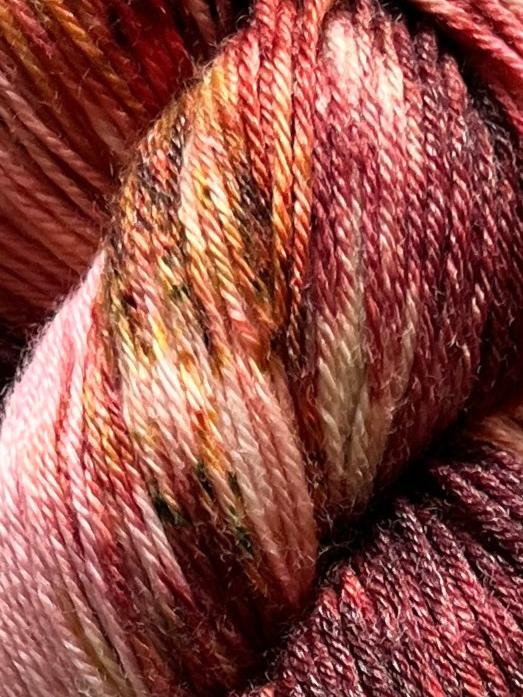 Håndfarvet garn i Merino Bamboo uld. Dette håndfarvede strømpegarn er farvet med smukke nuancer af bordeaux, pink og gylden brun